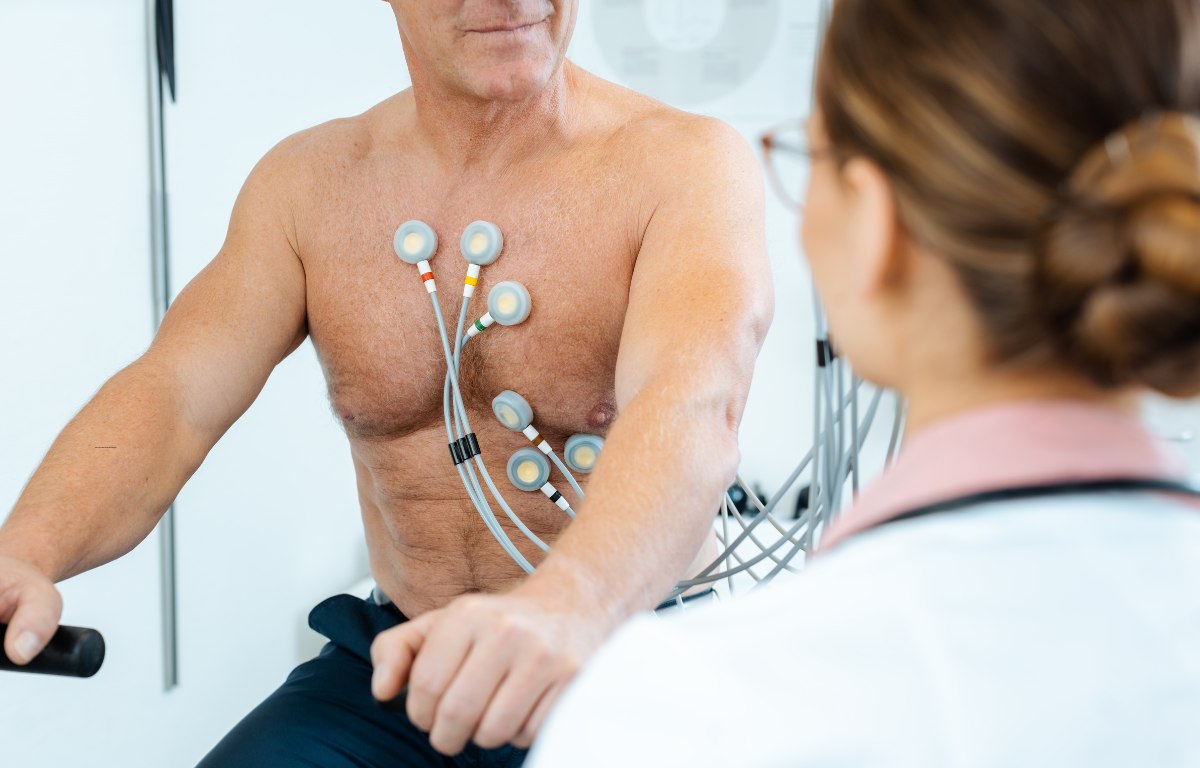 Belastungs-EKG: Patient mit angelegten Elektroden auf dem Fahrradergometer